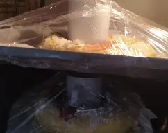 Step <p> <span style="font-weight: normal;">Haz tu propia cámara de fermentación casera, colocando un bote alto de cristal en el agujero de rosco y envolviendo la bandeja entera con papel film, cerrando todas las esquinas bien. El bote de cristal impedirá que la masa al fermentar llegue a tocar el papel film. Guarda la bandeja en el interior del horno apagado y vigila que dobla su volumen. Tardará aproximadamente una hora. Antes de hornear, recuerda sacar la bandeja del horno para precalentar.</span><br></p> illustration